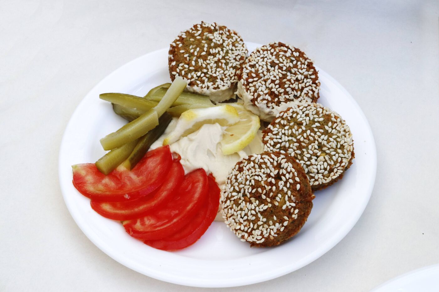 Falafel-Teller mit Tahini, Tomaten und Gurken